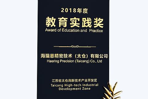 Schwarzes Blatt mit goldener Schrift "2018 Award of Education and Practice Häring Precision (Taicang) Co., Ltd Taicang High-tech Industrial Development Zone"