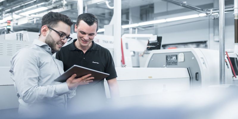 zwei männliche Mitarbeiter von Häring stehen an einer Maschine